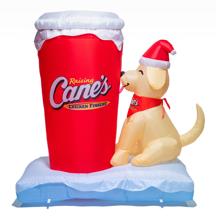 Inflatable cup with 'Raising Cane's' logo and a dog wearing a Santa hat on a white background