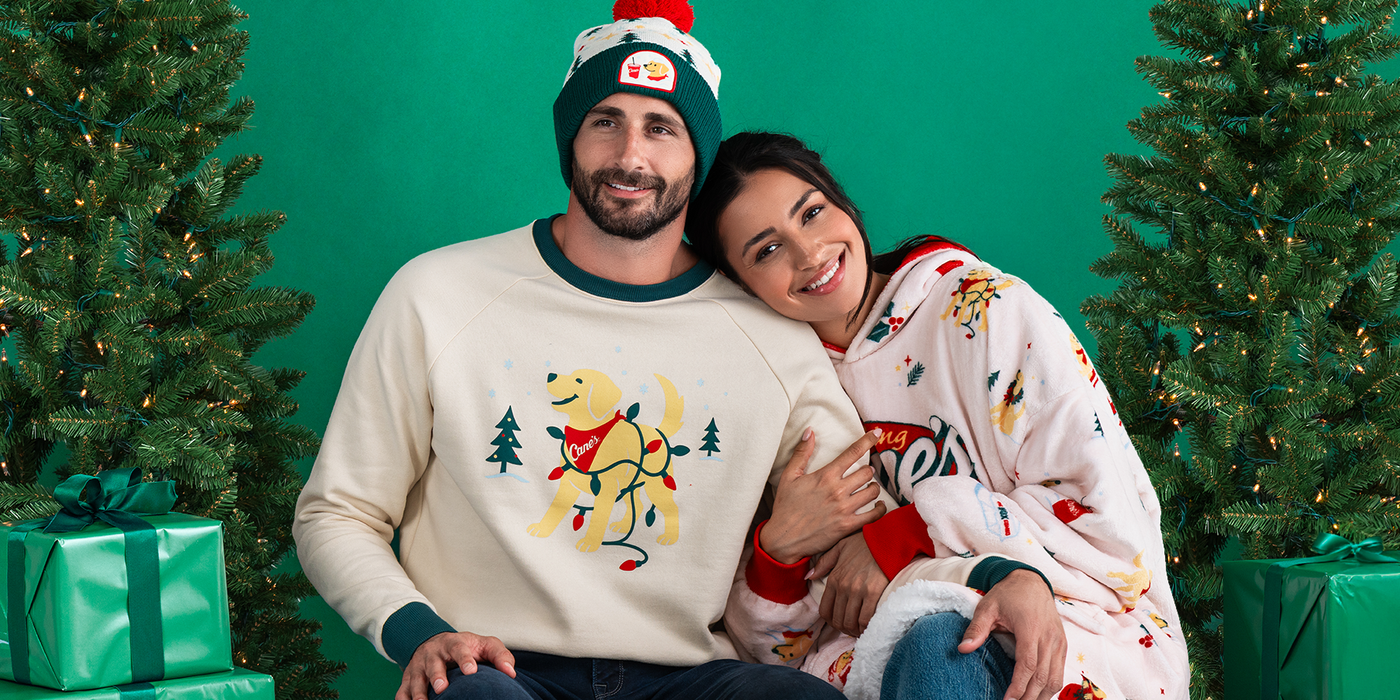 Male and female model wearing Cane's Holiday 2025 apparel against green background