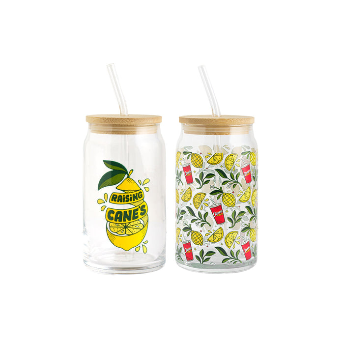 Two glass jars with straw lids featuring lemon and pineapple designs on a white background