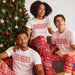 Three adults wearing holiday pajama set
