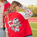 Model wearing Raising Cane's Varsity Raglan Jacket, showing back of item