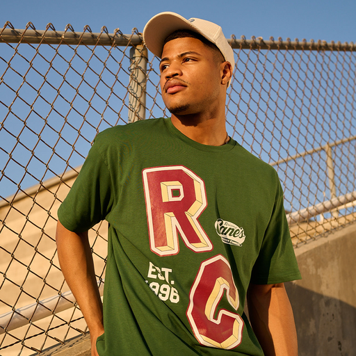 Model wearing Raising Cane's Varsity Tee, showing front of item