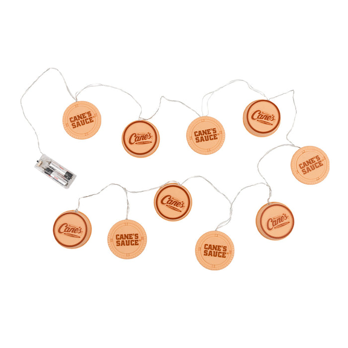 String of lights with Cane's Sauce labels on a white background
