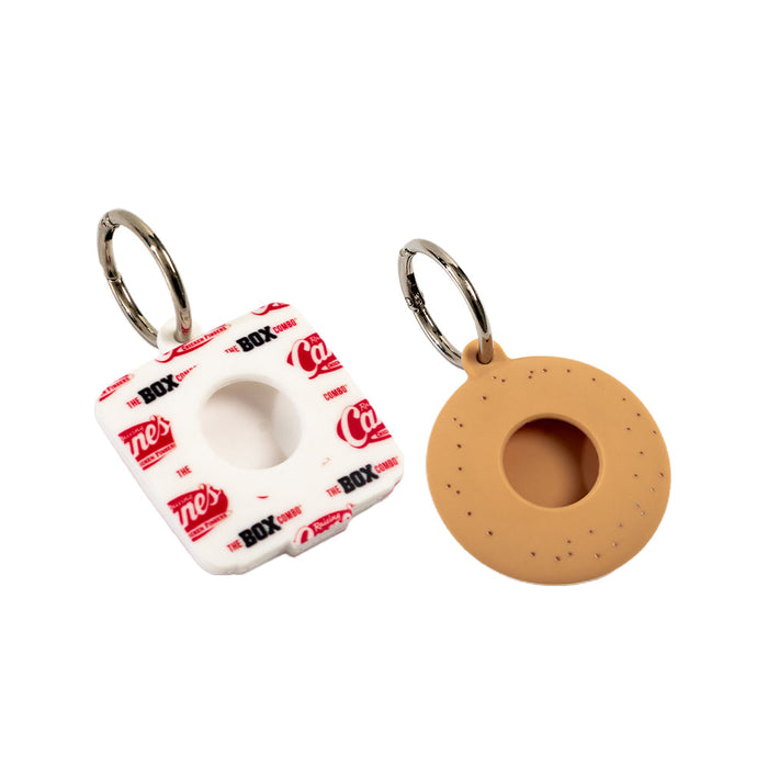 Two keychains, one white with red text and the other brown, on a white background.